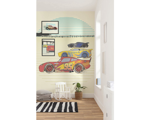 Kinderzimmer mit Wandtapete, die vom Film Cars inspiriert ist, mit einem Schaukelstuhl und einem Teppich