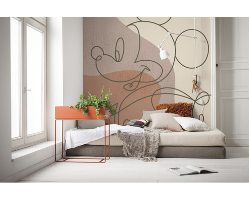 Dekoratives Zimmer mit Bett, Pflanzgefäß und Wandtapete mit Mickey Maus Motiv
