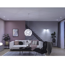 Wohnzimmer mit Sofa, Sessel, Lampe und Dekorartikeln