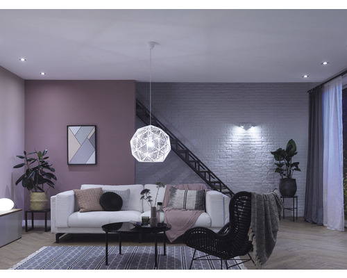 Wohnzimmer mit Sofa, Sessel, Lampe und Dekorartikeln