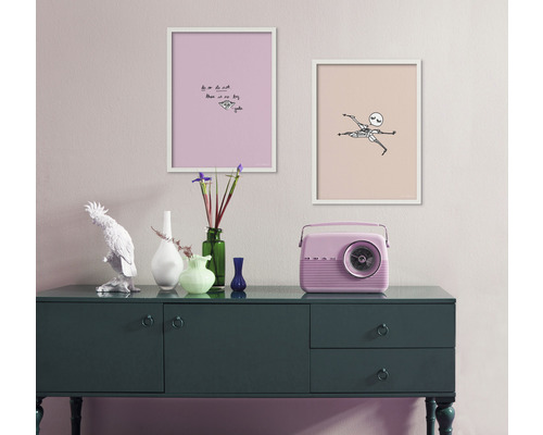 Dekoratives Interieur mit Kommode, zwei gerahmten Bildern und einem Radio