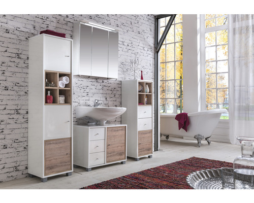 Badezimmer mit Waschtisch, Spiegelschrank, Hochschränken und Badewanne vor Fenster