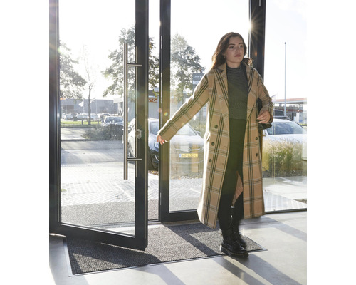 Eingangsbereich mit Schmutzfangmatte vor einer sich öffnenden Glastür