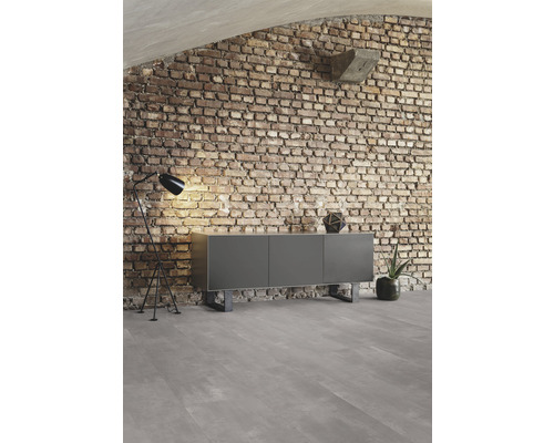 Wohnzimmer mit Sideboard, Stehlampe und Ziegelwand