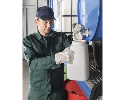 Eine Person füllt eine Flüssigkeit aus einem Fass in einen Kanister um.