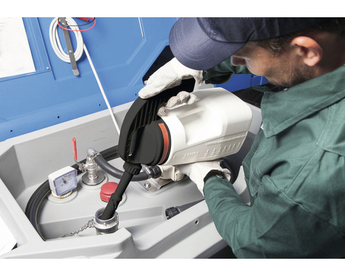 Eine Person gießt Flüssigkeit in eine Auffangwanne mit einem Kanister.