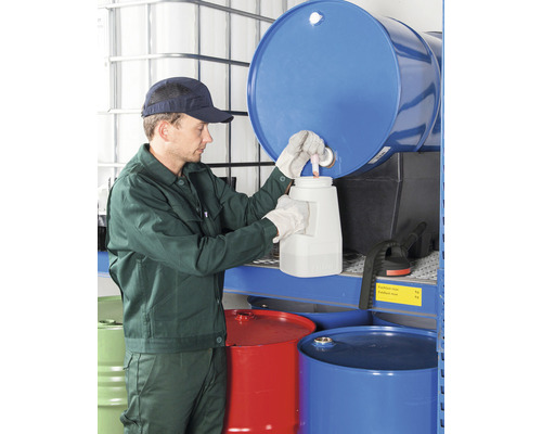 Mitarbeiter füllt Flüssigkeit aus einem Fass in einen Behälter