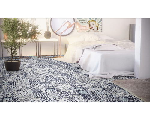 Schlafzimmer mit Bett und Vinylboden in Patchwork Optik.