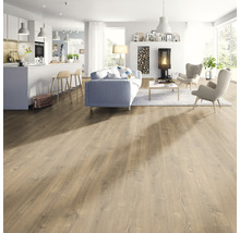 Heller Wohnraum mit Holzboden, Sofa, Sesseln und Kamin.