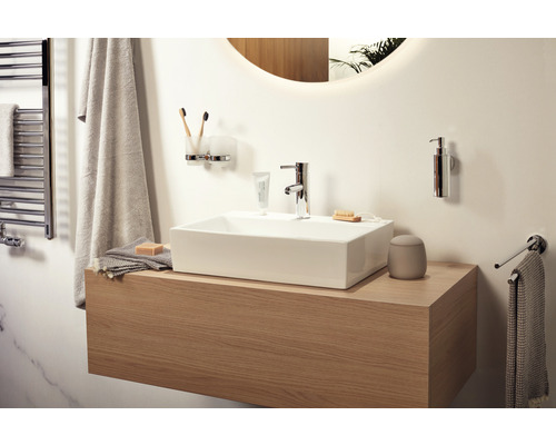 Helles Badezimmer mit Waschbecken, Armatur, Handtüchern und Badaccessoires.