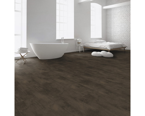 Heller Raum mit Badewanne, Bett und dunkelbraunem Bodenbelag in Holzoptik