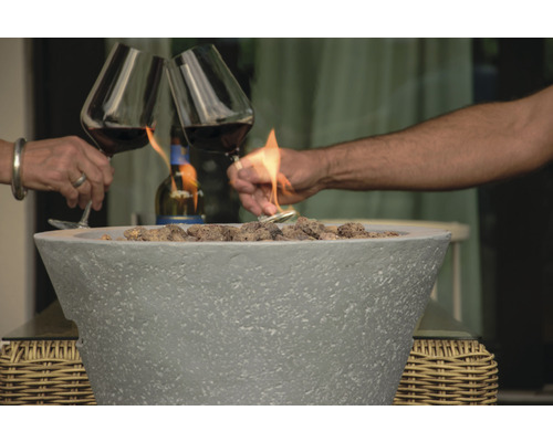 Feuerstelle mit zwei Personen, die mit Weingläsern anstoßen