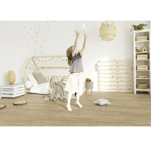 Mädchen spielt in einem hellen Kinderzimmer mit Holzboden, Hausbett und Sternen-Wanddekoration.