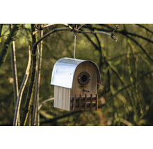 Holzvogelhaus mit Metalldach hängt an einem Baum