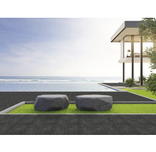 Außenbereich mit zwei Steinsitzmöbeln, Pool und modernem Haus am Meer