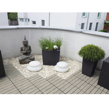 Balkon mit Buddha Statue, Pflanzgefäßen, Dekosteinen und Terrassenfliesen