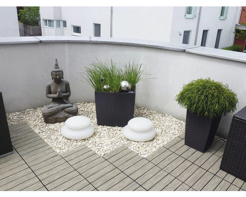 Balkon mit Buddha Statue, Pflanzgefäßen, Dekosteinen und Terrassenfliesen