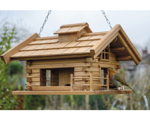 Vogelhaus im Blockhausstil mit Kette und Vogel