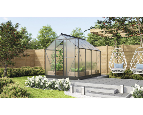 Gewächshaus im Garten mit Bepflanzung und Sitzgelegenheiten