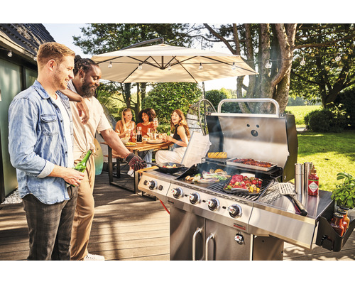 Szene mit Personen, die an einem Edelstahl-Gasgrill im Freien grillen