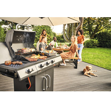 Szene mit Grillparty im Garten, Grill mit Speisen und Menschen an einem Tisch