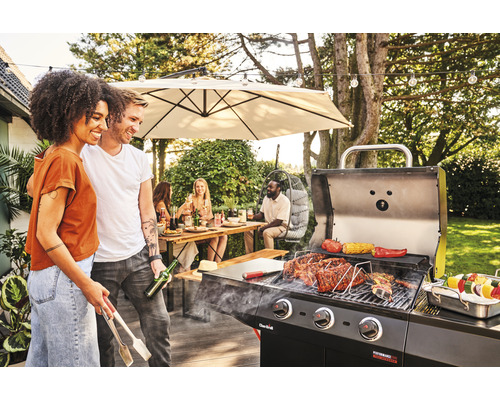 Szene mit einem Grill, auf dem Speisen zubereitet werden, und Menschen, die sich im Freien aufhalten