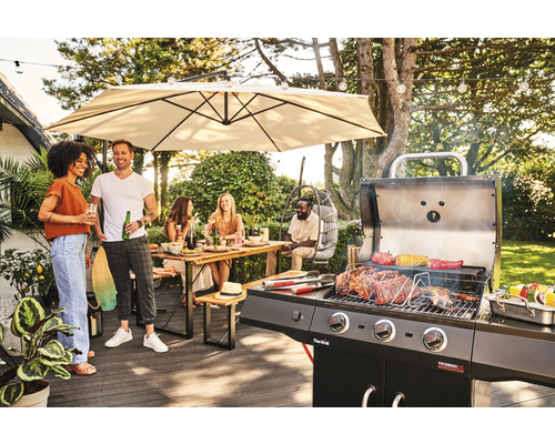 Eine Grillparty im Garten mit Grill, Esstisch und Sonnenschirm.