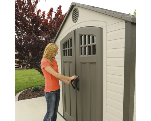 Frau öffnet Gartenschuppen mit Doppeltür und Fenster