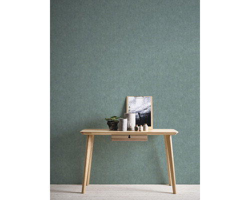 Heller Holztisch mit Schublade, Dekoration und Bild vor einer Wand