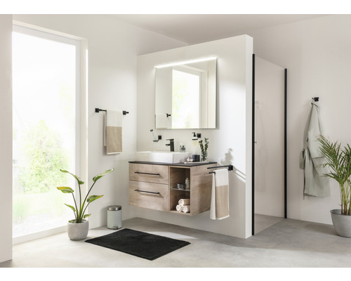 Helles Badezimmer mit Waschtisch, Spiegel mit Beleuchtung, Handtuchhaltern, Dusche und Zimmerpflanzen
