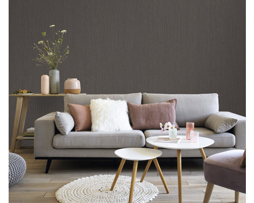 Wohnzimmer mit Sofa, Couchtischen und strukturierter Tapete