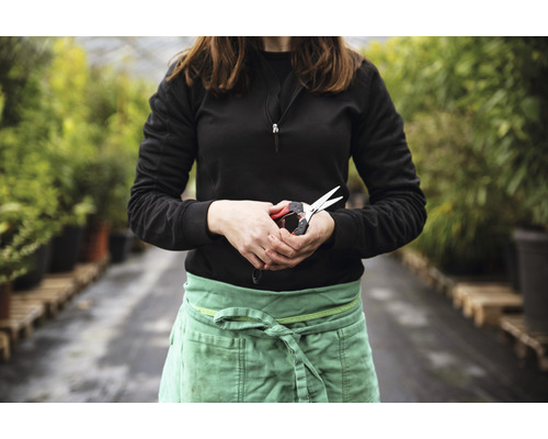 Eine Person hält eine Gartenschere in einem Gartencenter.