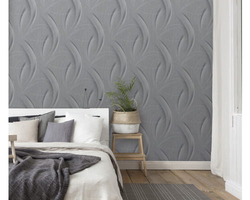 Schlafzimmer mit grauer dreidimensionaler Tapete und weißem Bett