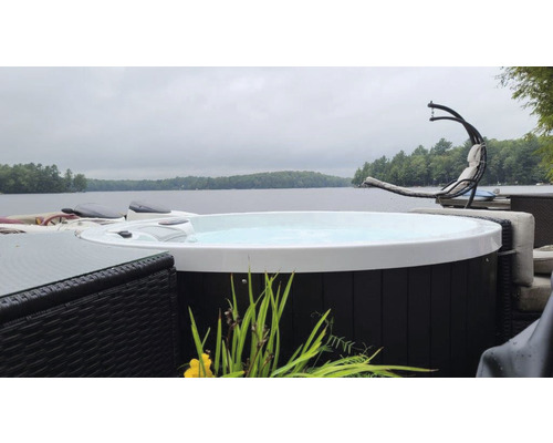 Runder Whirlpool im Außenbereich mit Blick auf einen See