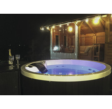 Beleuchteter Whirlpool im Gartenpavillon mit Champagnergläsern