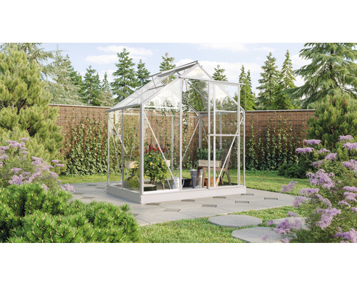 Gewächshaus im Garten mit Pflanzen und Gartengeräten