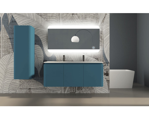 Badezimmer mit blauem Waschtischunterschrank, Spiegelschrank mit Beleuchtung und Hochschrank vor einer gemusterten Tapete.