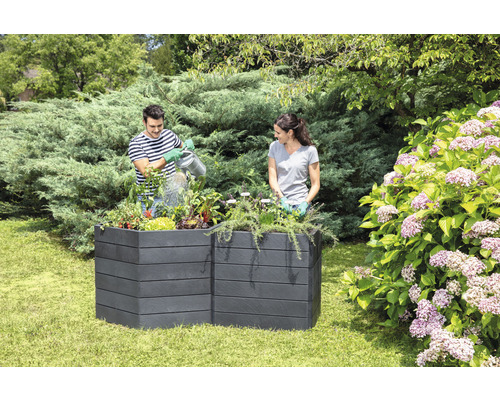 Zwei Personen im Garten, die einen Hochbeetkasten aus Kunststoff bepflanzen