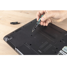 Ein Mann repariert einen Laptop mit einem Schraubendreher