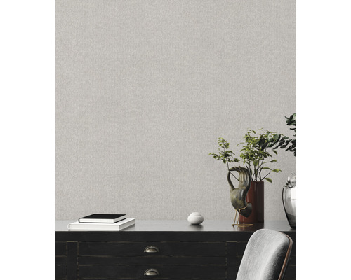 Helle gemusterte Tapete an einer Wand über einer Kommode.