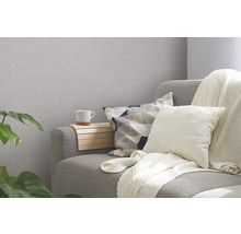 Wohnzimmer mit Couch, Kissen, Decke und einem Getränk auf einem Holztablett