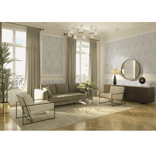 Wohnzimmer mit Sofa, Sesseln, Couchtisch, Kommode, Spiegel, Stehlampe, Zimmerpflanze, Vorhängen und Tapete