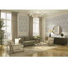 Wohnzimmer mit Sofa, Sesseln, Couchtisch und dekorativer Tapete