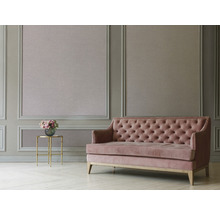 Wohnzimmer mit Wandvertäfelung, Sofa mit Knopfheftung und einem Beistelltisch mit Blumenstrauß