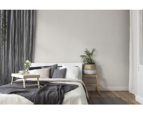 Schlafzimmer mit Bett, Kissen, Decke, Vorhängen und Pflanzen