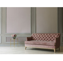Rosa Sofa mit Knopfheftung in einem dekorierten Raum