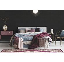 Schlafzimmer mit Bett, Nachttisch, Stuhl und gemusterter Tapete