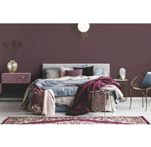 Schlafzimmer mit Bett, Nachttisch und dekorativer Wandtapete.