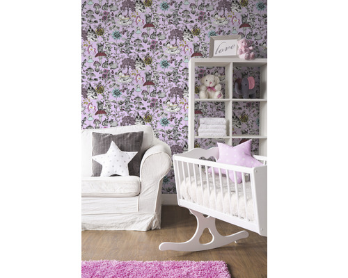 Kinderzimmer mit weißer Wiege, Regal und Sofa vor einer Tapete mit Tiermotiven