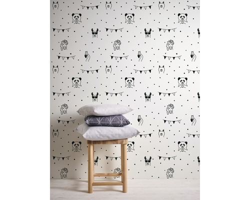 Tapete mit Tiermotiven und Punktmuster auf hellem Grund, dazu ein Hocker mit Kissen